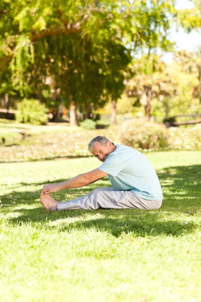 Mature man doing his streches in the park — Stock Photo, Image