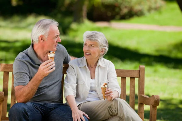 高级夫妇在一条长凳上吃冰淇淋 — 图库照片