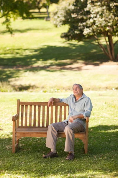 Ηλικιωμένος κάθεται σε ένα παγκάκι — Φωτογραφία Αρχείου