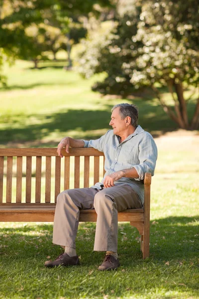 Пожилой человек сидит на скамейке — стоковое фото