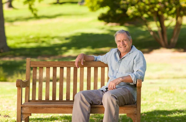 Starszy mężczyzna siedzący na ławce — Zdjęcie stockowe