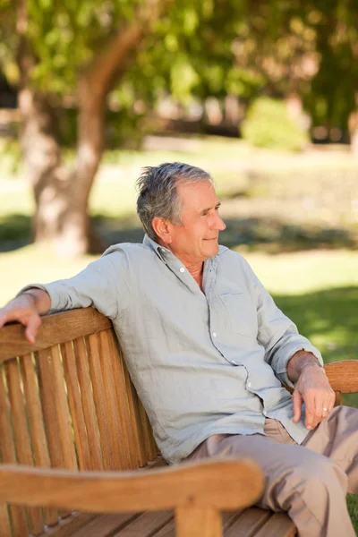Uomo anziano seduto su una panchina — Foto Stock