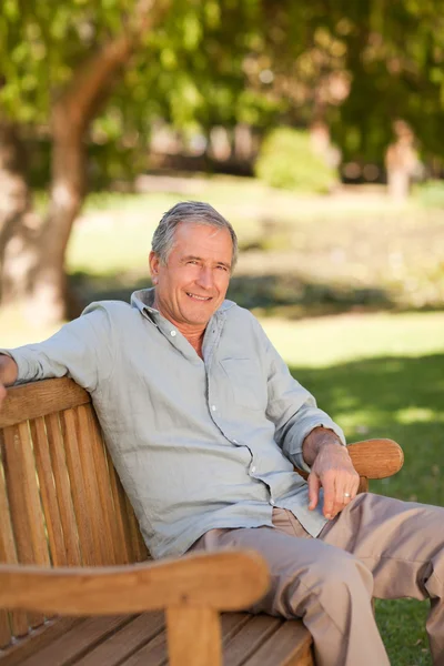 Starszy mężczyzna siedzi na ławce — Zdjęcie stockowe