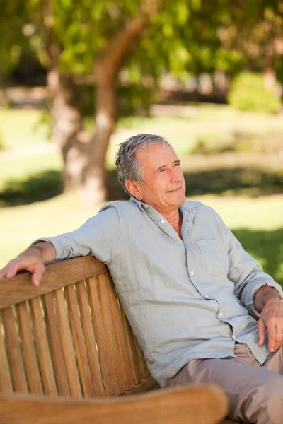 Starší muž, sedící na lavičce — Stock fotografie