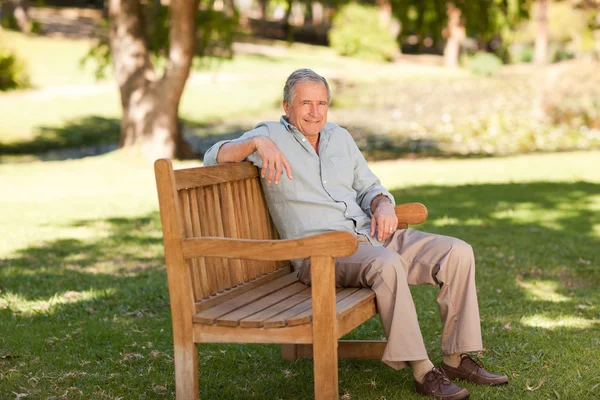 Hombre mayor sentado en un banco — Foto de Stock