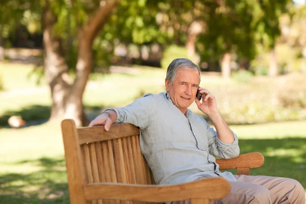 退休的老人在公园打电话 — 图库照片