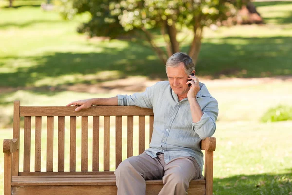 Un uomo in pensione che telefona nel parco — Foto Stock