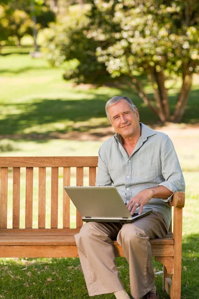 공원에 그의 노트북에서 일 하는 은퇴한 남자 — 스톡 사진