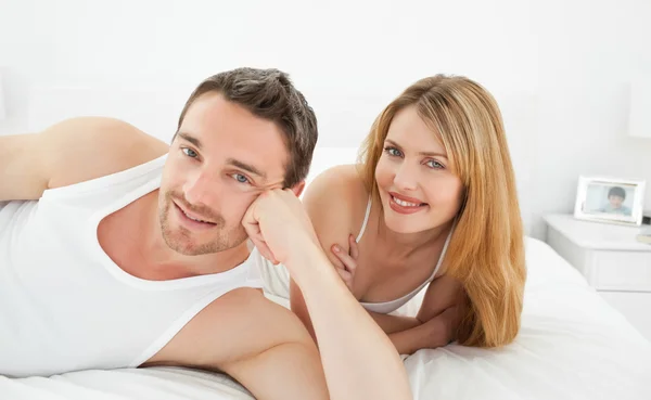 Couple lying down together in their bed Stock Image