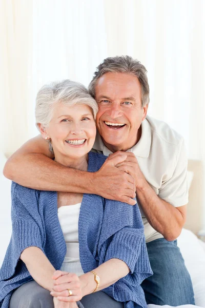 Senior couple hugging on their bed Stock Picture