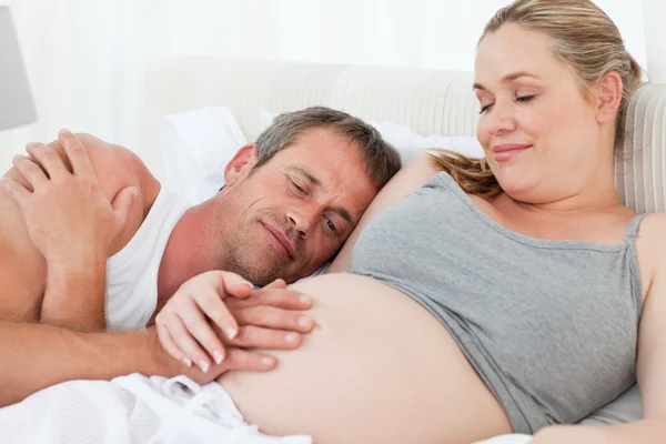 Husband listening to his wife's belly Royalty Free Stock Images