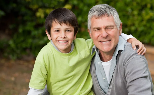 Grandfather with his grandson looking at the camera in the garde Royalty Free Stock Photos