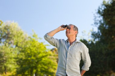 Man looking at the sky with his binoculars clipart