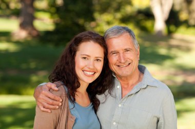 Woman with her father-in-law in the park clipart