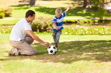 Father playing football with his son clipart