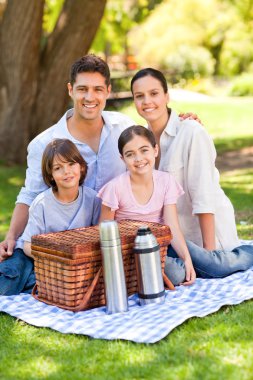 Happy family picnicking in the park clipart