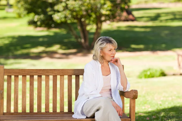Starší žena myslet na lavičce — Stock fotografie
