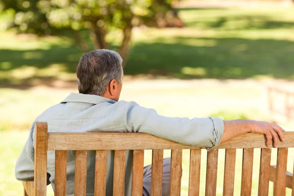 Elderly man sitting on the bench with his back to the camera — Stock Photo, Image