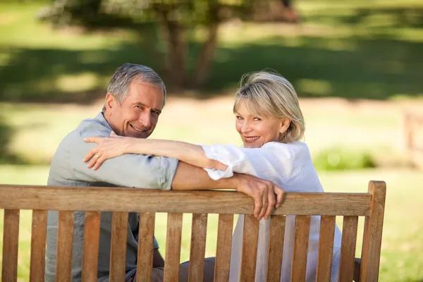 坐在长凳上的快乐退休的夫妇 — 图库照片