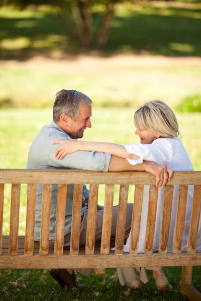 Счастливая пара на пенсии сидит на скамейке запасных — стоковое фото