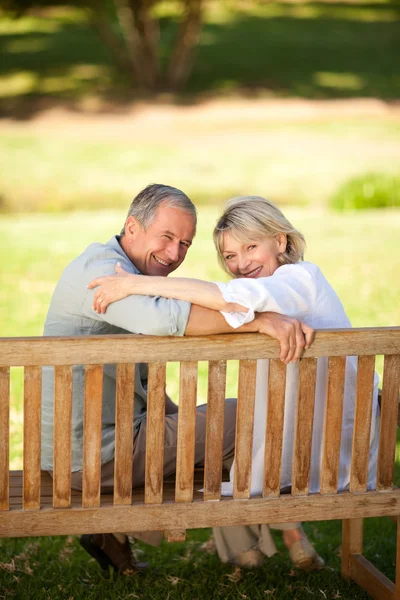 Glad pensionerat par sitta på bänken — Stockfoto