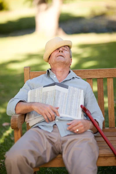 Homem idoso dormindo no banco — Fotografia de Stock