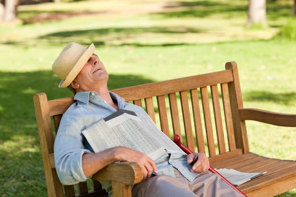 Homem idoso dormindo no banco — Fotografia de Stock