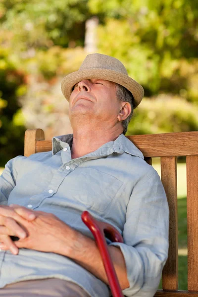 Uomo anziano che dorme sulla panchina — Foto Stock