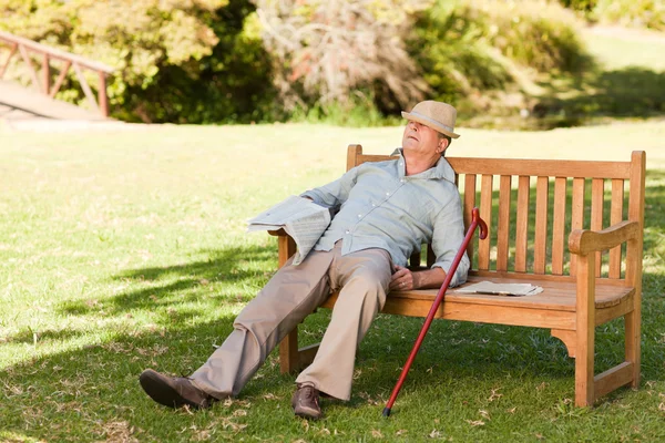 Hombre mayor durmiendo en el banco — Foto de Stock