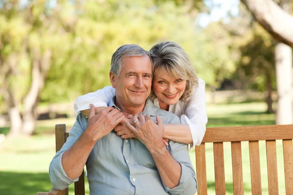 Senior vrouw haar echtgenoot die op de Bank te knuffelen — Stockfoto
