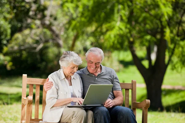 Пожилая пара смотрит на свой ноутбук — стоковое фото