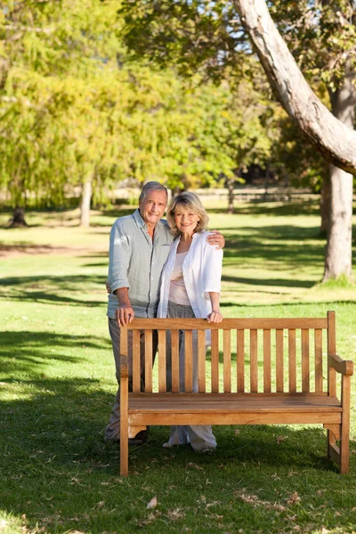Retrato de um lindo casal atrás do banco — Fotografia de Stock