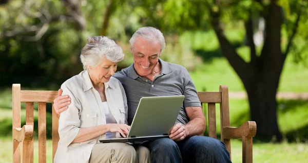 Älteres Ehepaar blickt auf seinen Laptop — Stockfoto