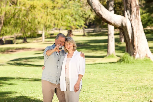 Casal de idosos tirando uma foto de si mesmos no parque — Fotografia de Stock