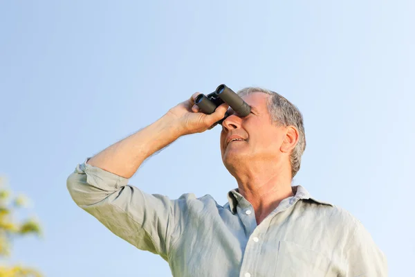 Hombre mirando al cielo con sus prismáticos —  Fotos de Stock