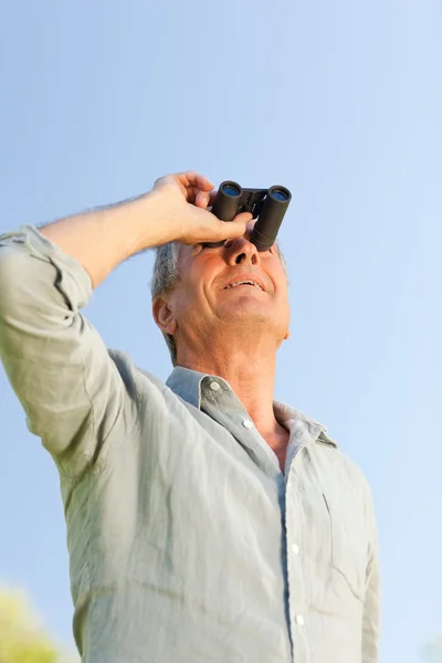 Man op zoek naar de hemel met zijn verrekijker — Stockfoto