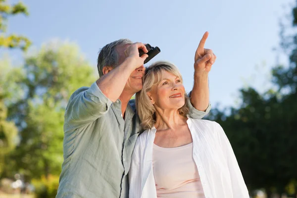 Couple looking at the sky with their binoculars — Stock Photo, Image