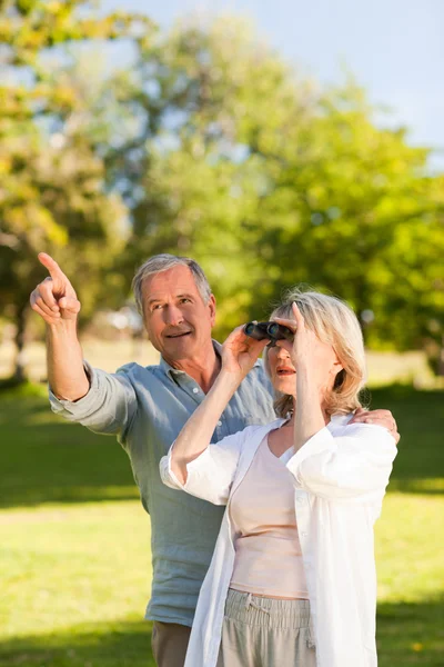 Couple looking at the sky with their binoculars — Stock Photo, Image