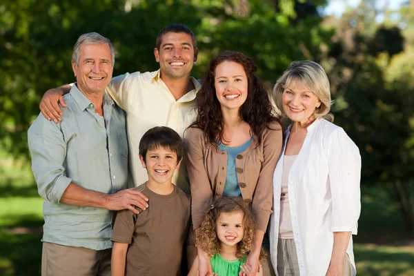 Family looking at the camera in the park — Stock Photo, Image