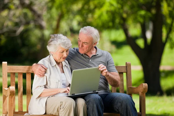 Ηλικιωμένο ζευγάρι ψάχνει στο lap-top τους — Φωτογραφία Αρχείου