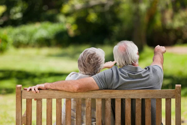 Couple sitting on the bench with their back to the camera — Stock Photo, Image