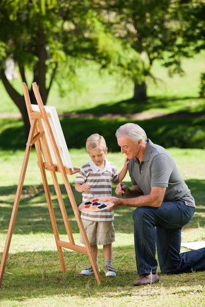 Avô e seu neto pintando no jardim — Fotografia de Stock