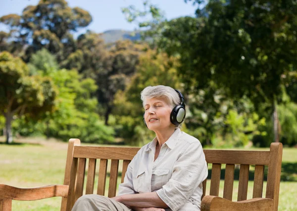 Elderly woman listening to some music — Stock Photo, Image