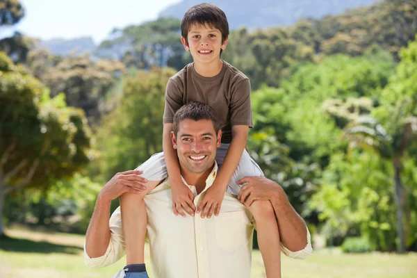 Man die geeft zoon een piggyback — Stockfoto