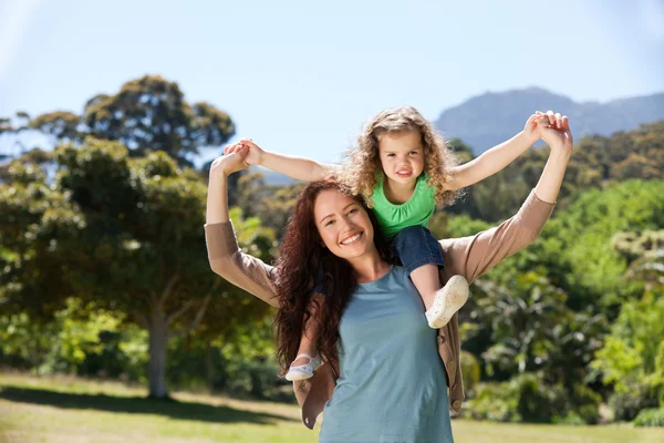 Kobieta podając córka piggyback — Zdjęcie stockowe