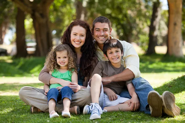 Happy family sitting in the garden — Stock Photo, Image