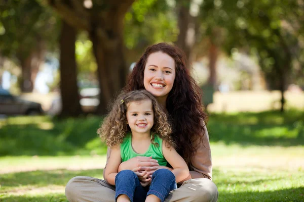 Mother with her daughter sitting in the garden — Stock Photo, Image