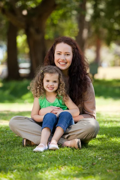 Mother with her daughter sitting in the garden — Stock Photo, Image
