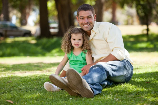 Vader met zijn dochter zittend op de tuin — Stockfoto