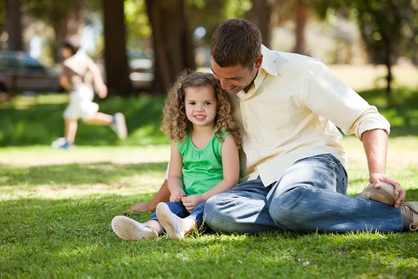 Отец со своей дочерью сидит в саду — стоковое фото